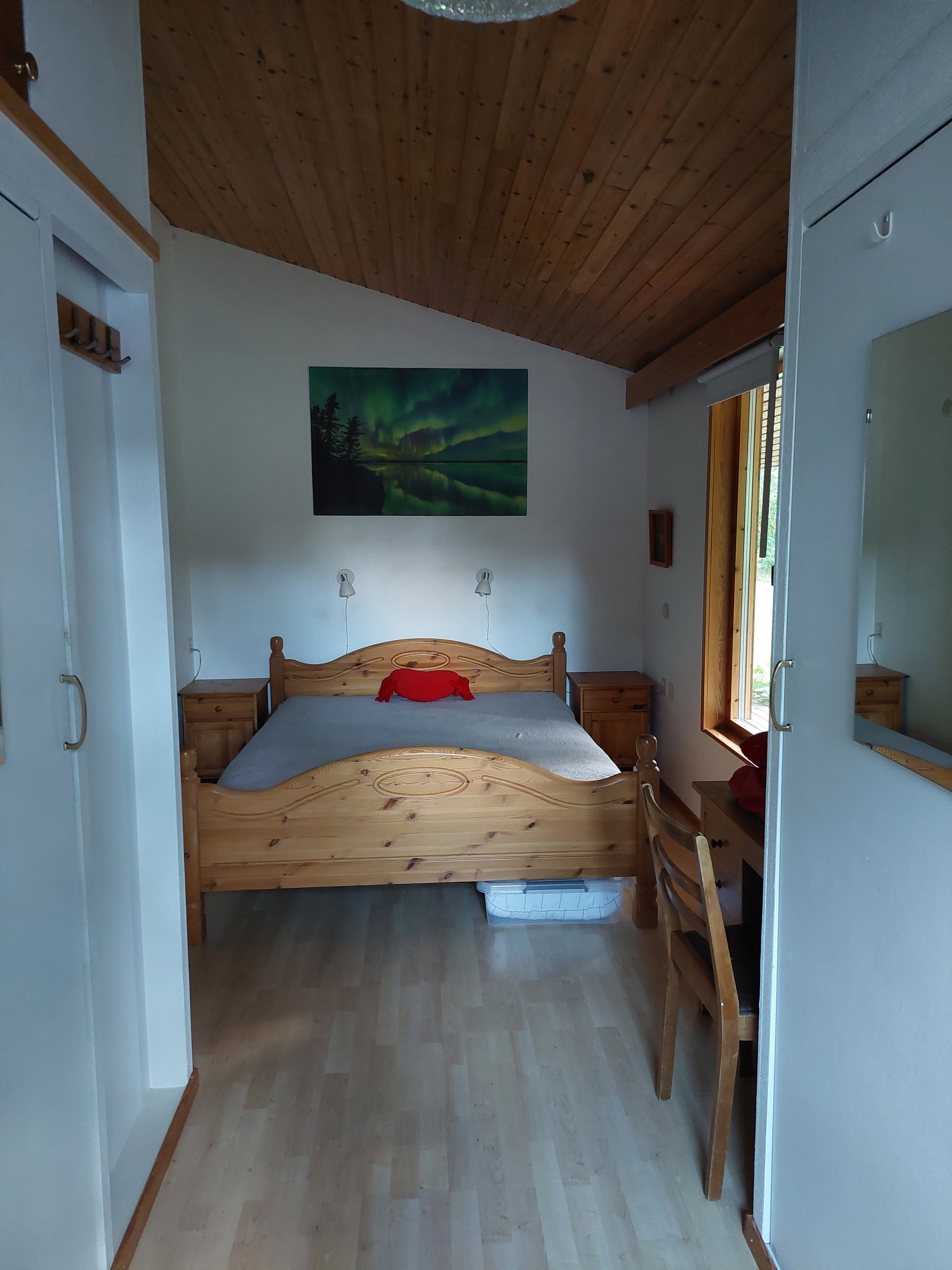 Master bedroom with a wooden double bed and skylight